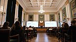 Widok na zabytkową Aulę Główną AGH, w której zgromadzeni uczestnicy obserwują uroczystość inauguracji roku akademickiego.