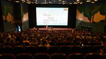 Wielka sala kinowa z ekranem pokazująca konferencje